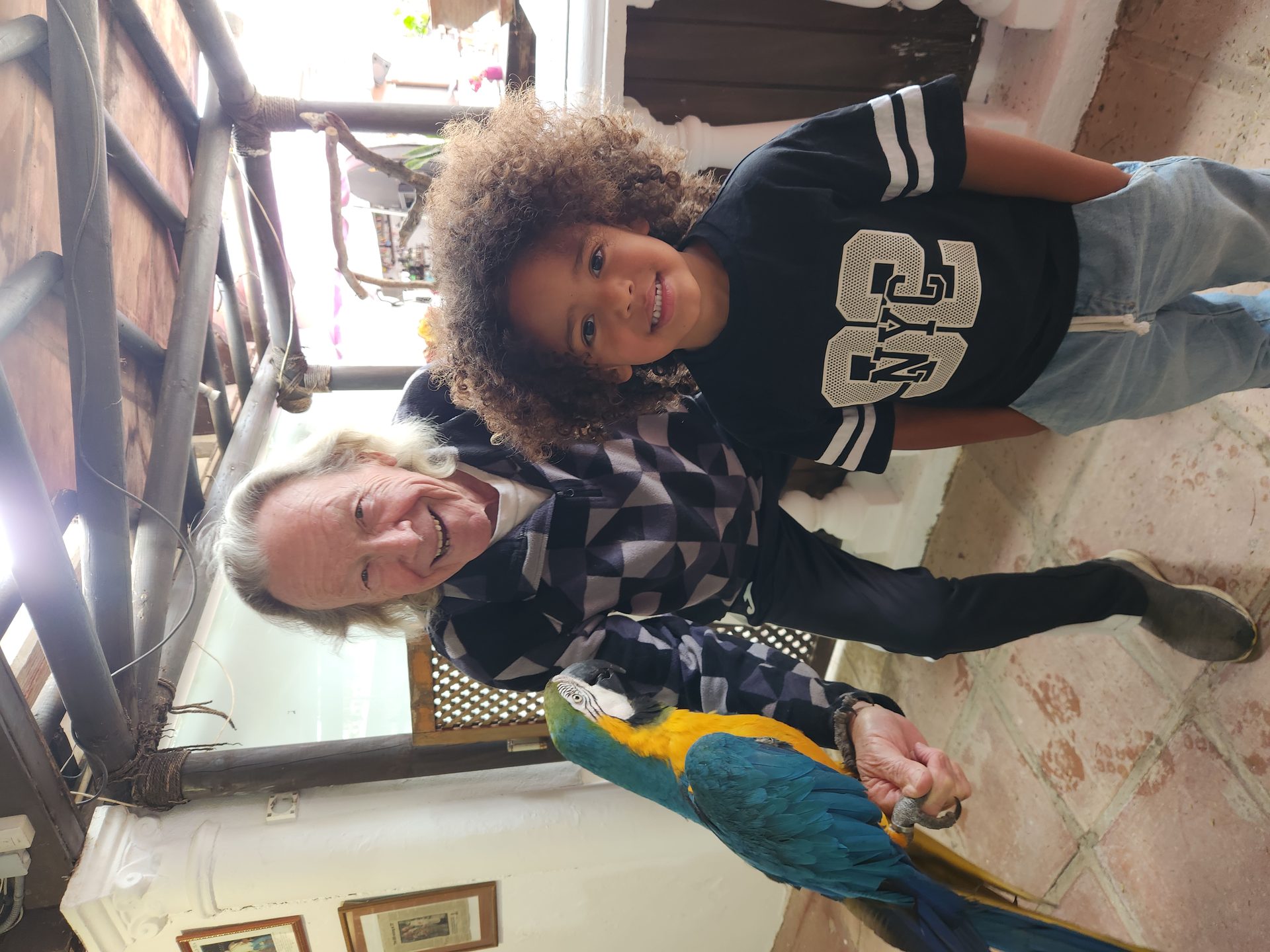 Paul Hickling with his famous macaw parrot and a young visitor